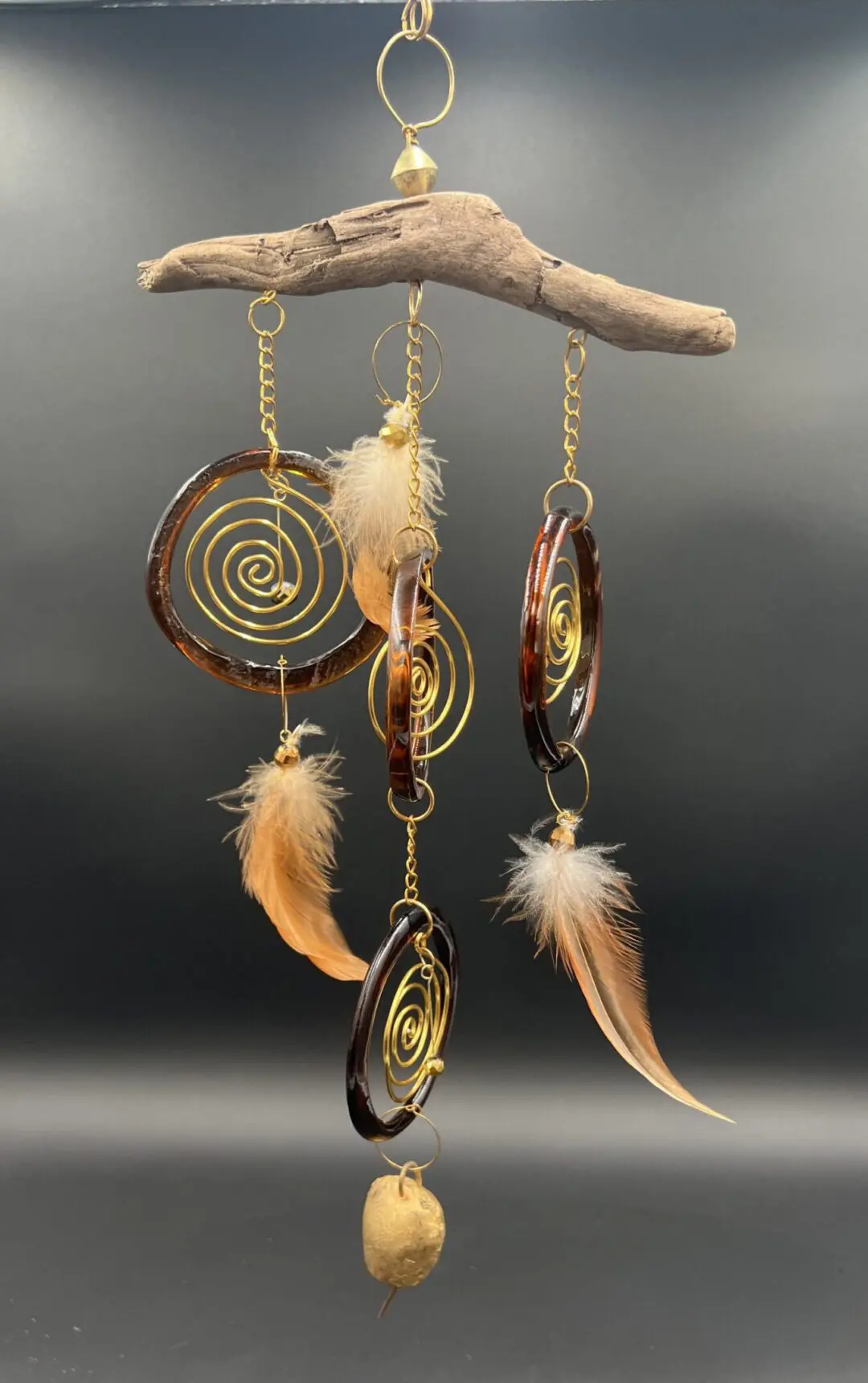 Decorative hanging ornament with feathers and spirals.