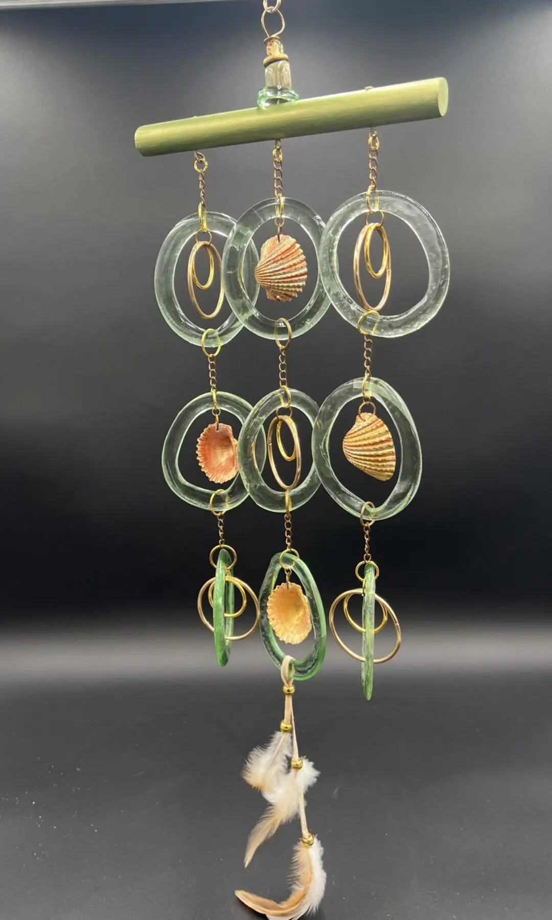 Hanging wind chime with shells and feathers.