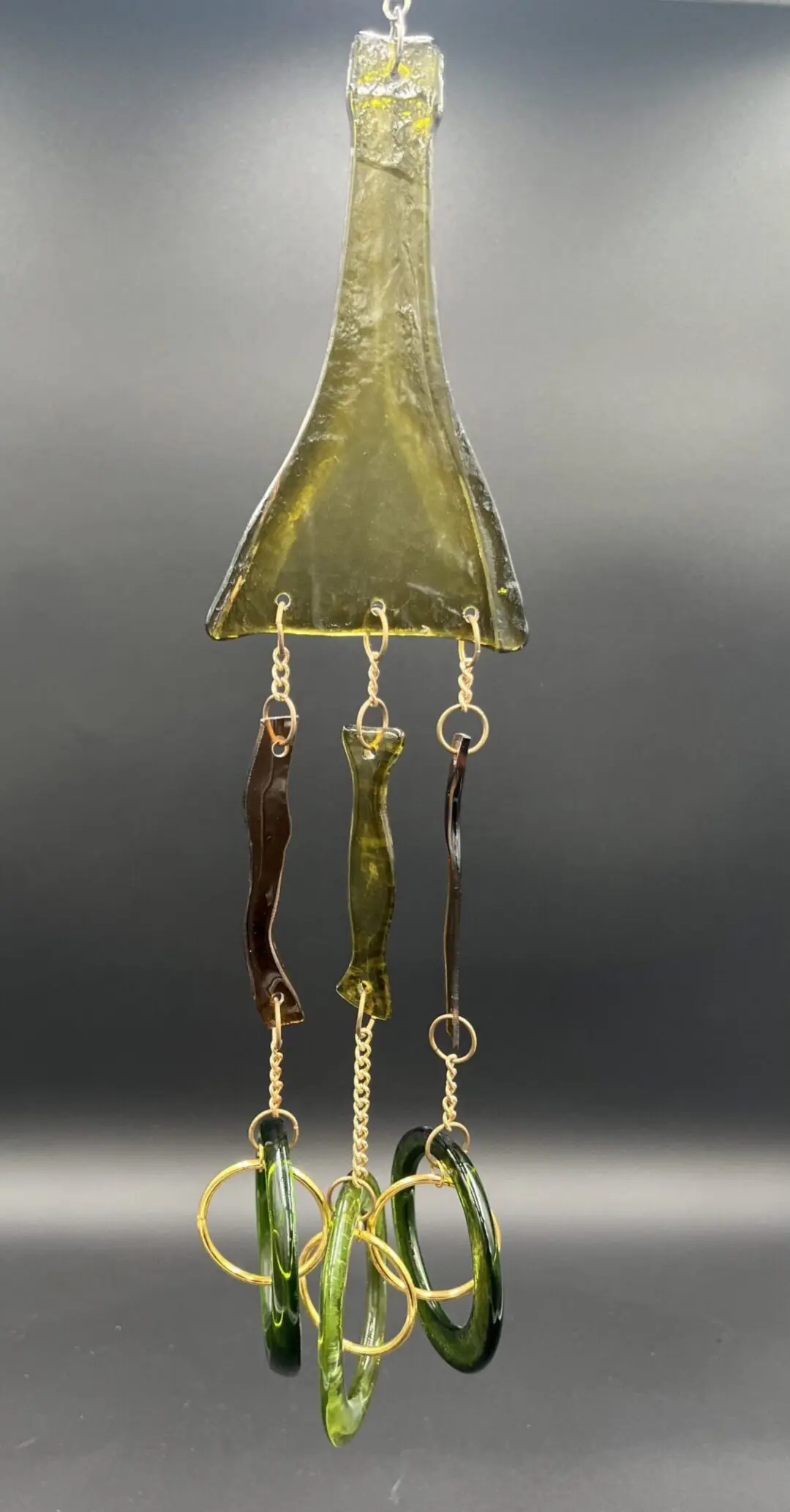 Green glass wind chime with hanging rings.