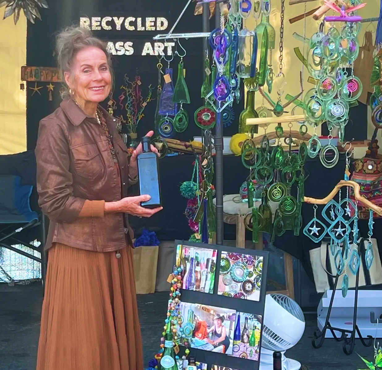 Esther displaying colorful recycled glass art.